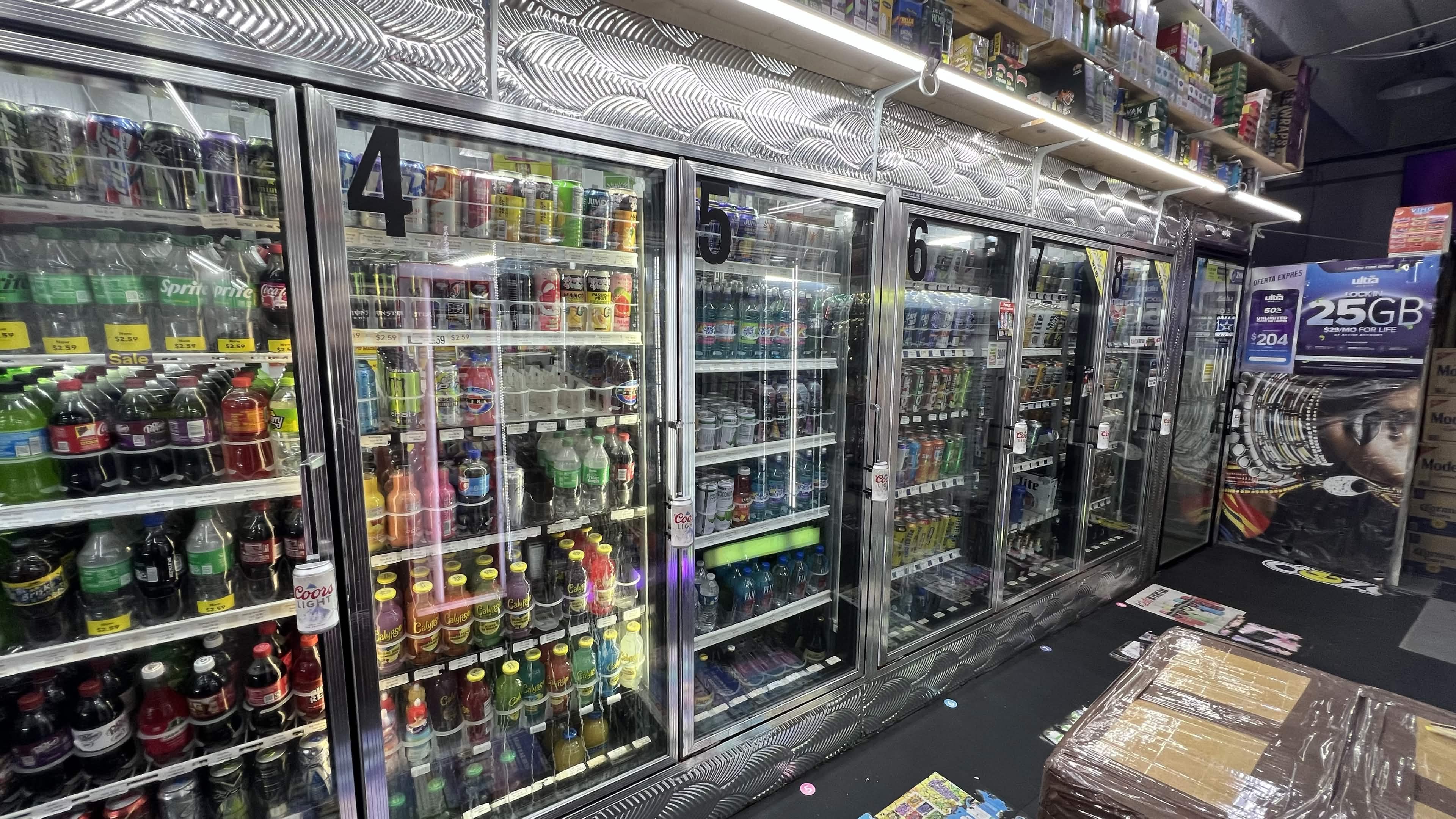 Long line of glass-door coolers filled with soda, water, juice and beer inside Tobacco Brew & Chew